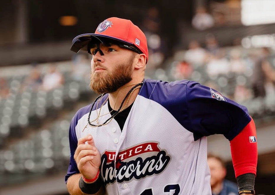 Baseball player wearing Maris Optics flip-up sunglasses on the field, sunglasses flipped up.